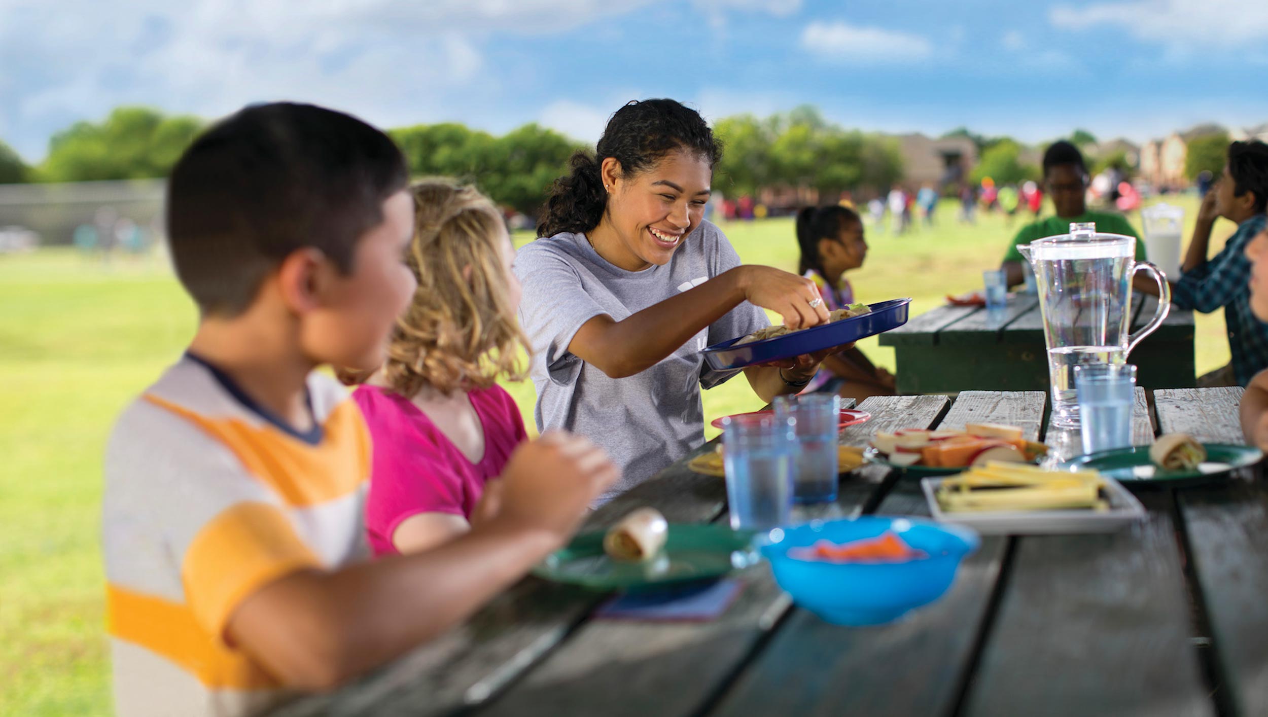 Children share a picnic lunch with a counselor