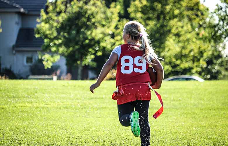 Youth girl running with football