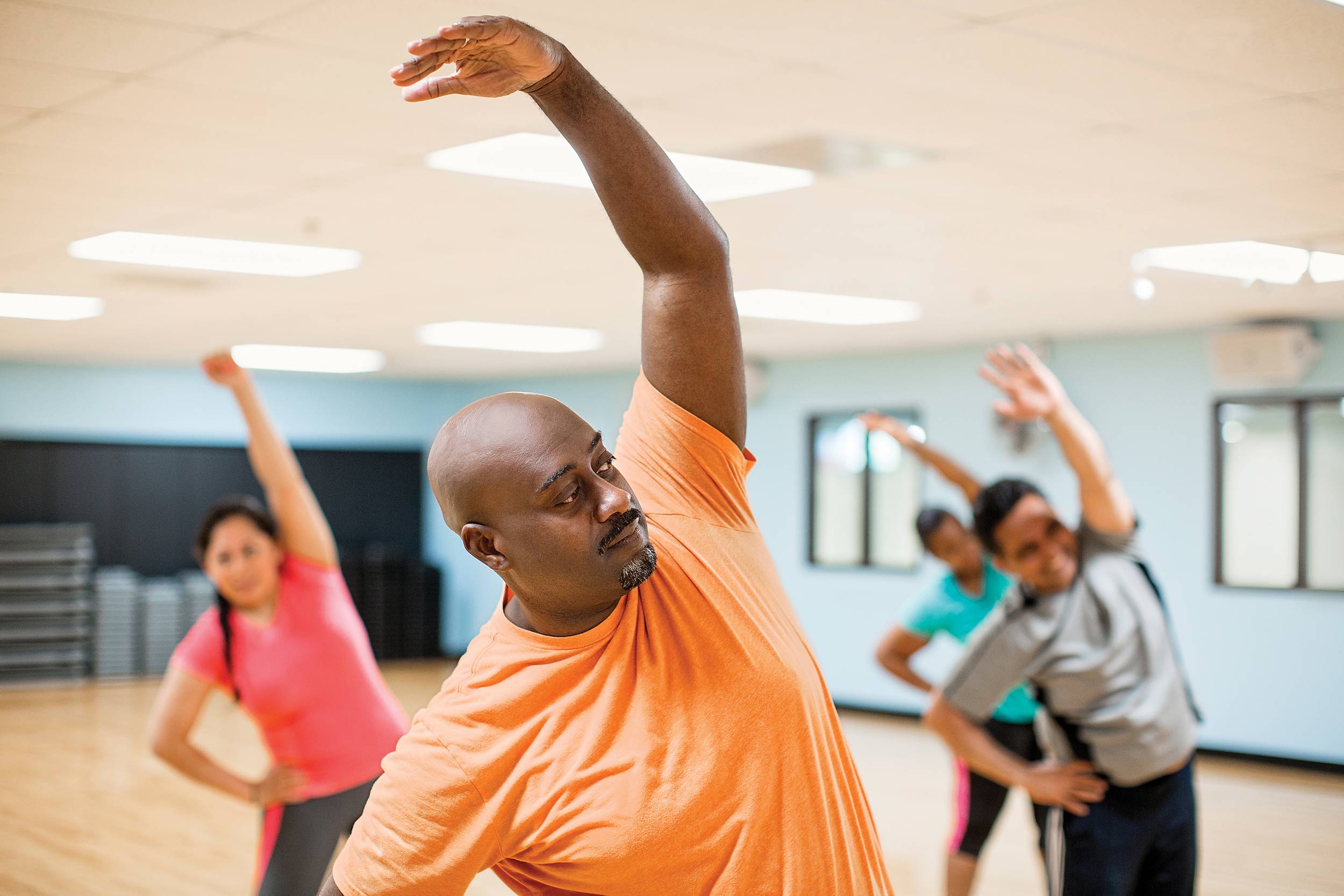 Man stretches during group exercise class