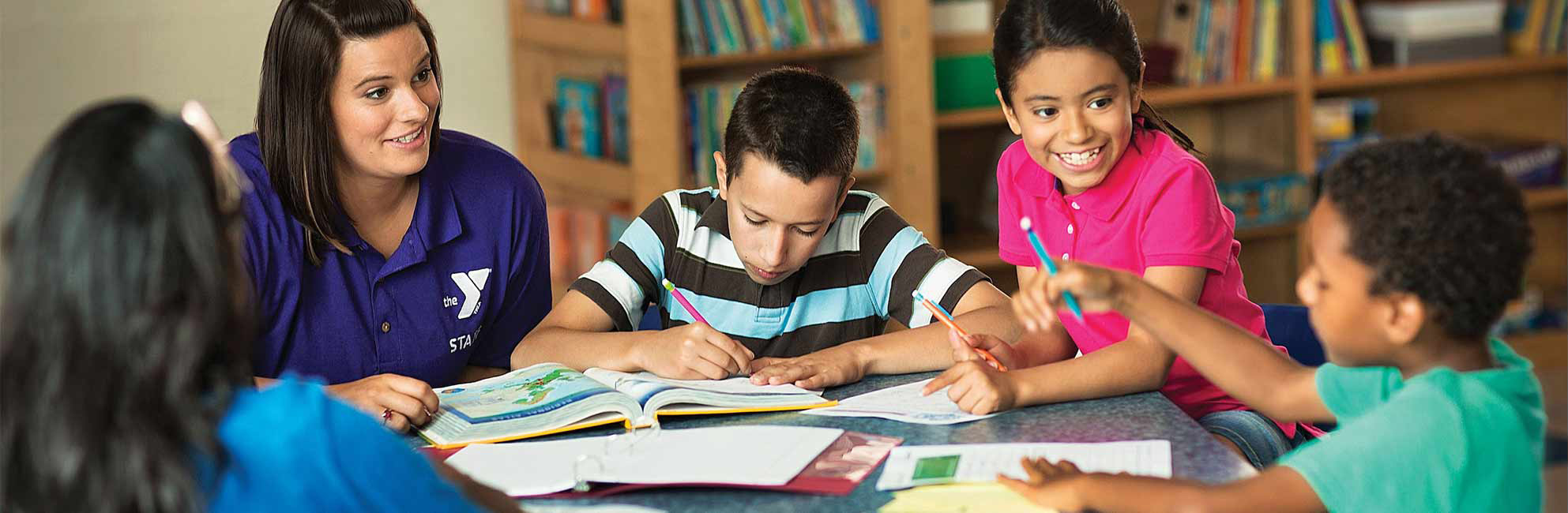 Tudor helps children with homework at table
