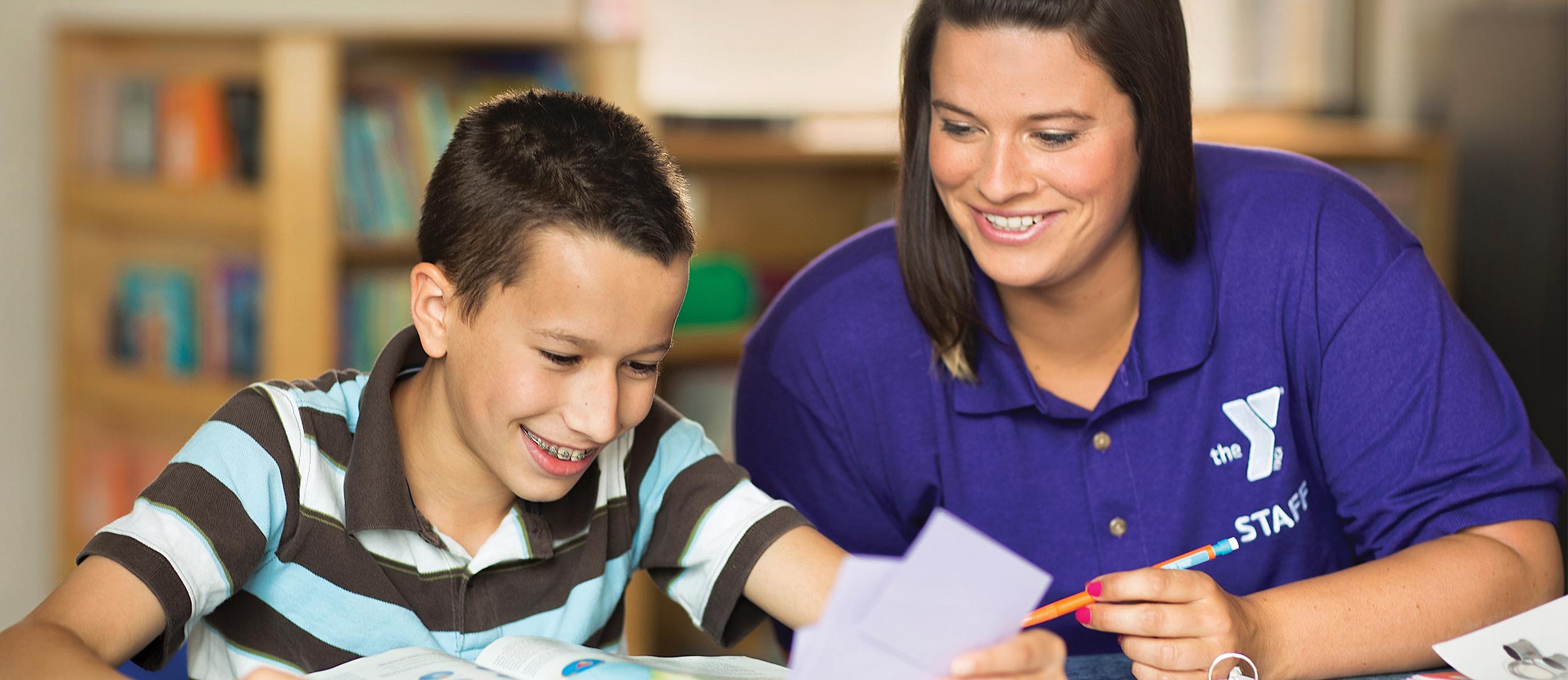 YMCA Volunteer helps youth with his homework
