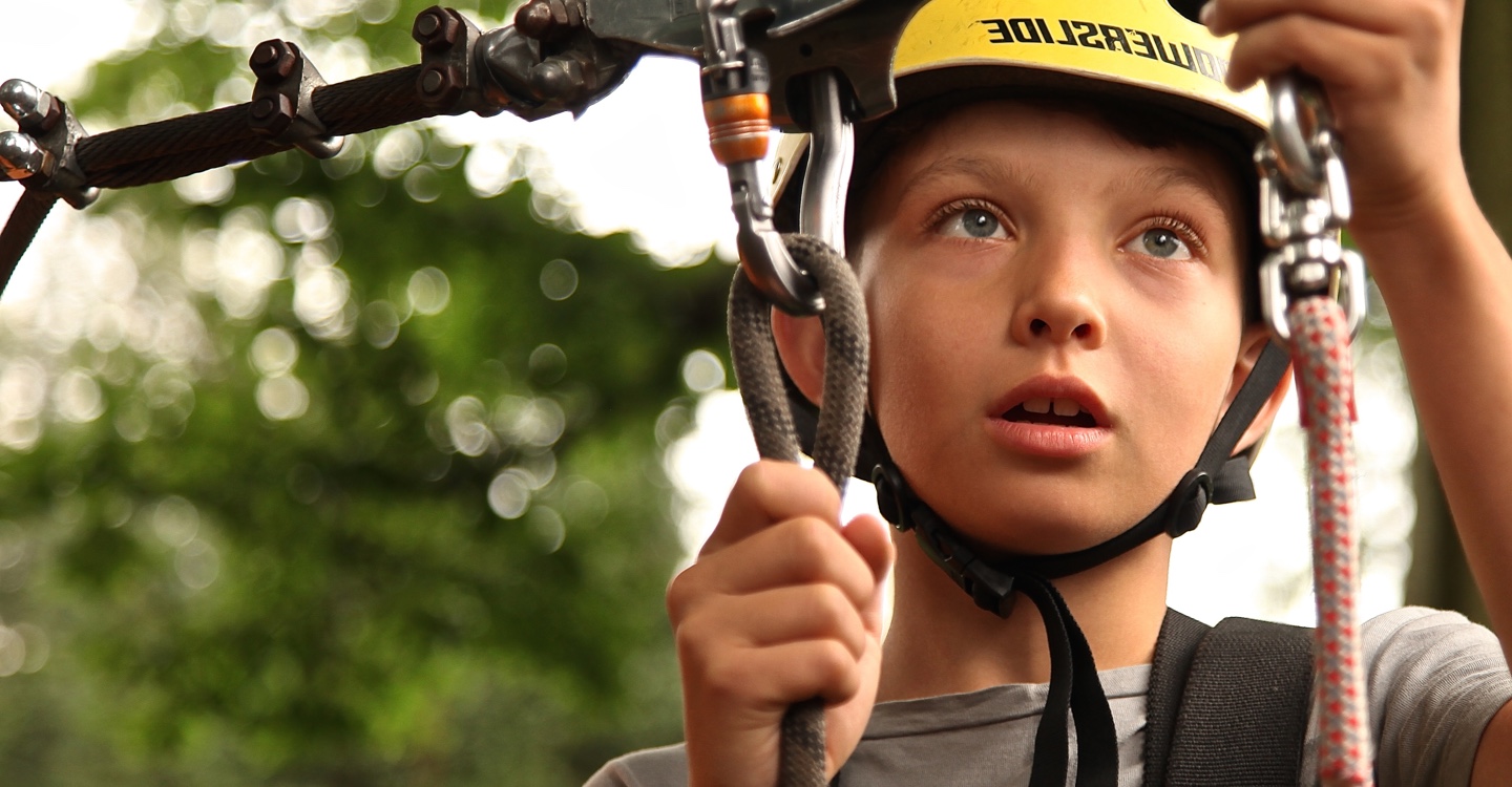 Young boy plays on rope course