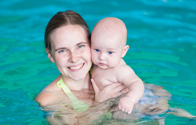 Mother holding baby in water